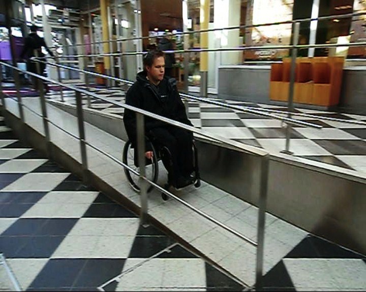 Åka ner för en inomhus ramp med rullstol
